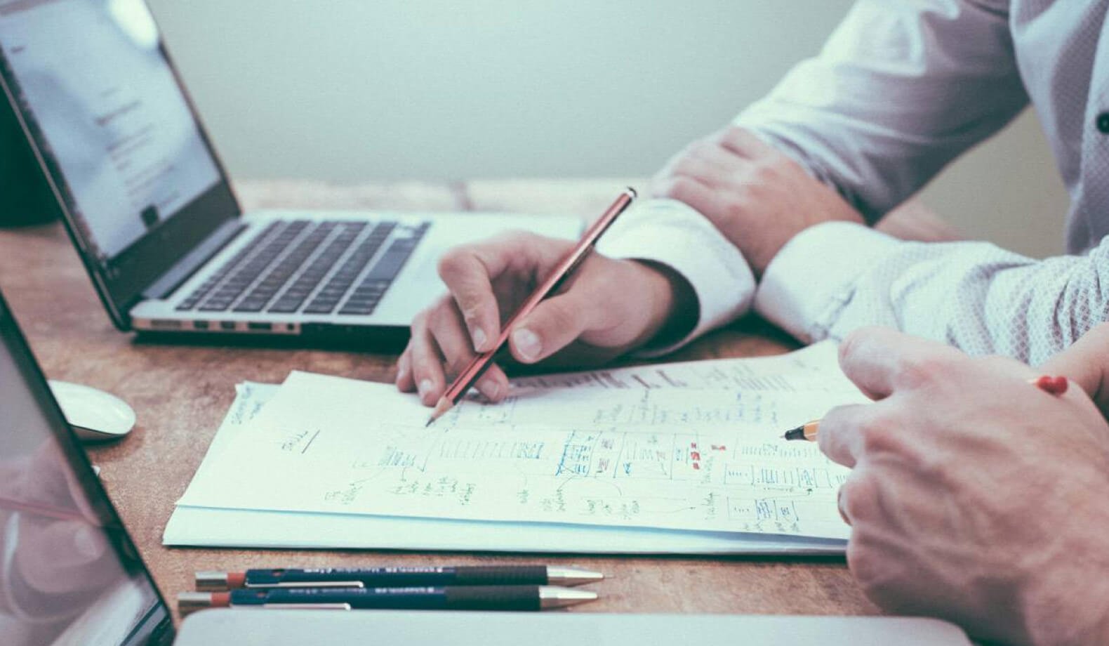 Two people at a desk looking through financial paperwork. Photo by Scott Graham on Unsplash. 